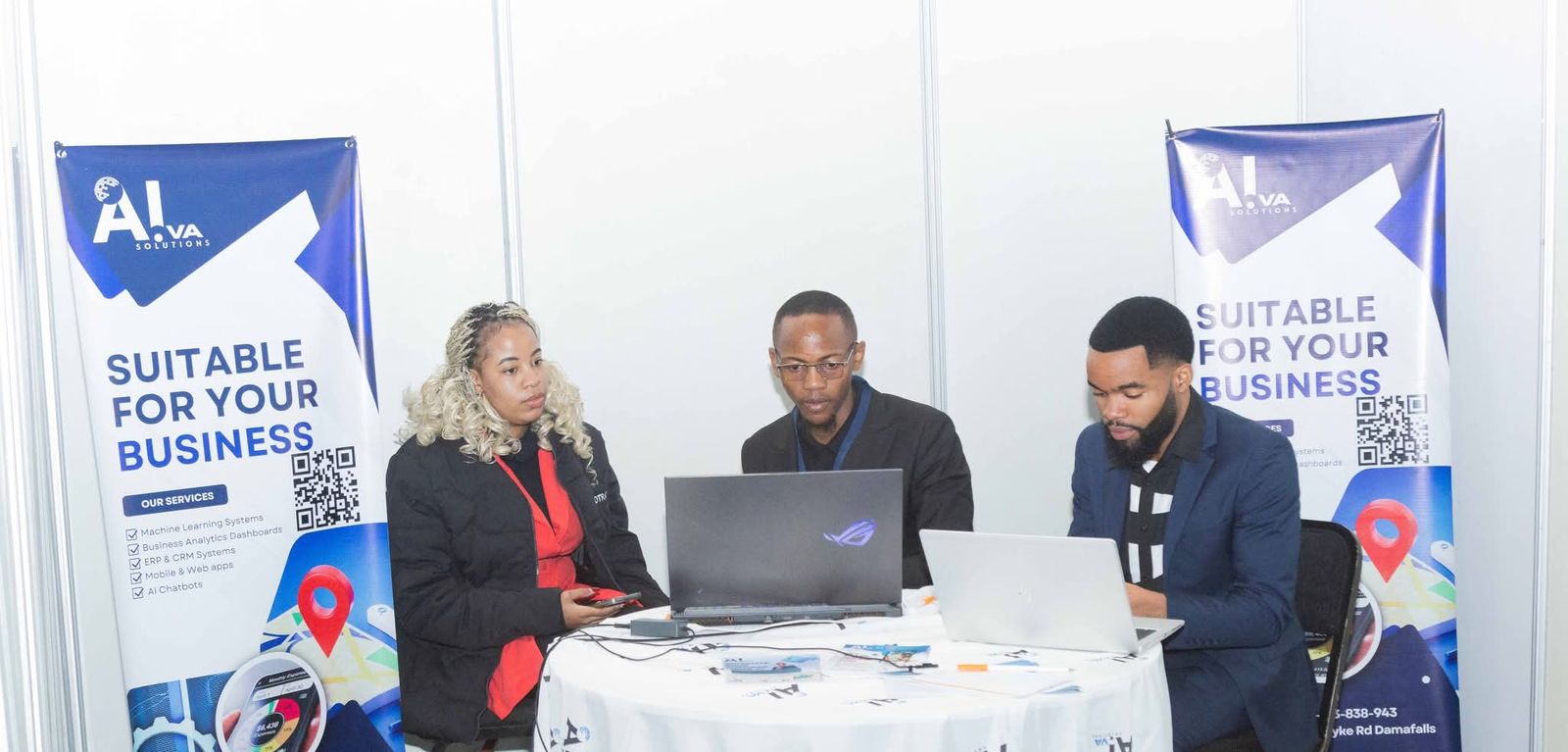 Three members of the AIVA Solutions team demonstrating software on laptops at the AIVA exhibition stand
